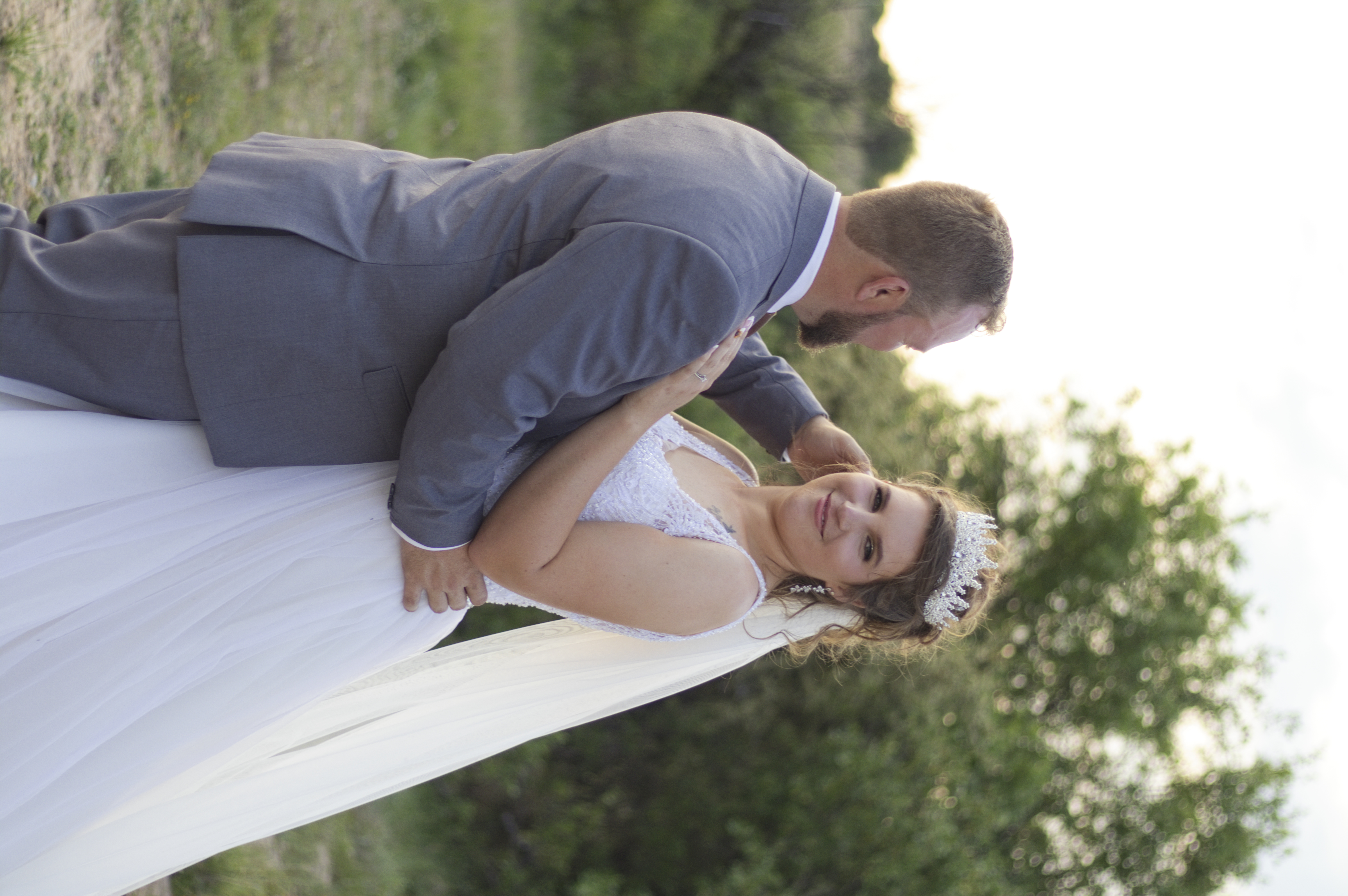 Bride glancing at the camera in the groom's embrace