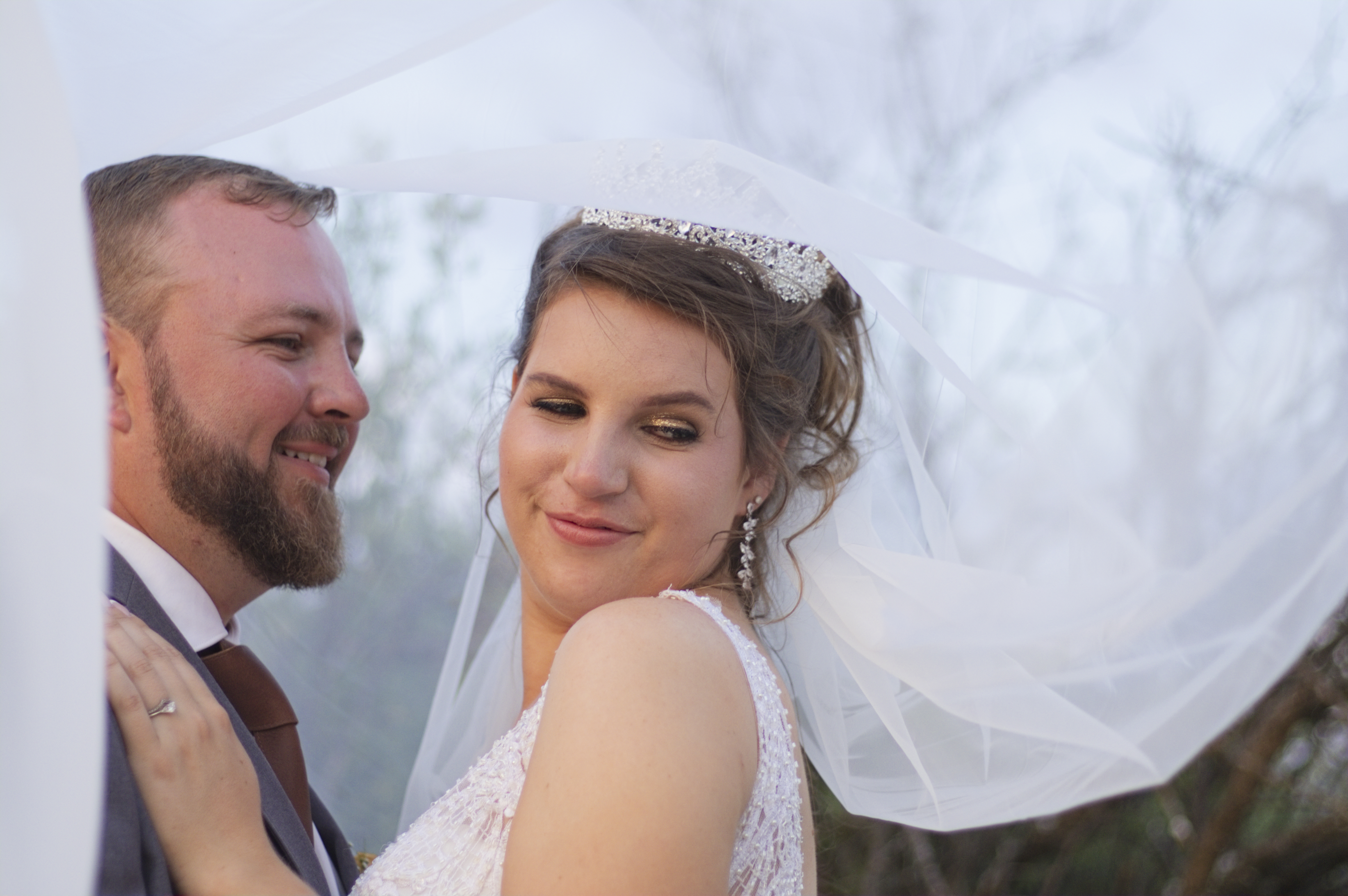 Bride smiling over her shoulder beneath a flowing veil