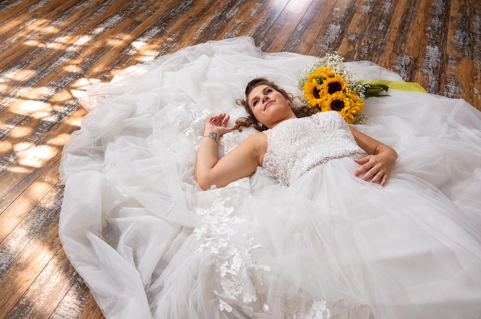 Dreamy bride resting among lace and tulle with sunflowers