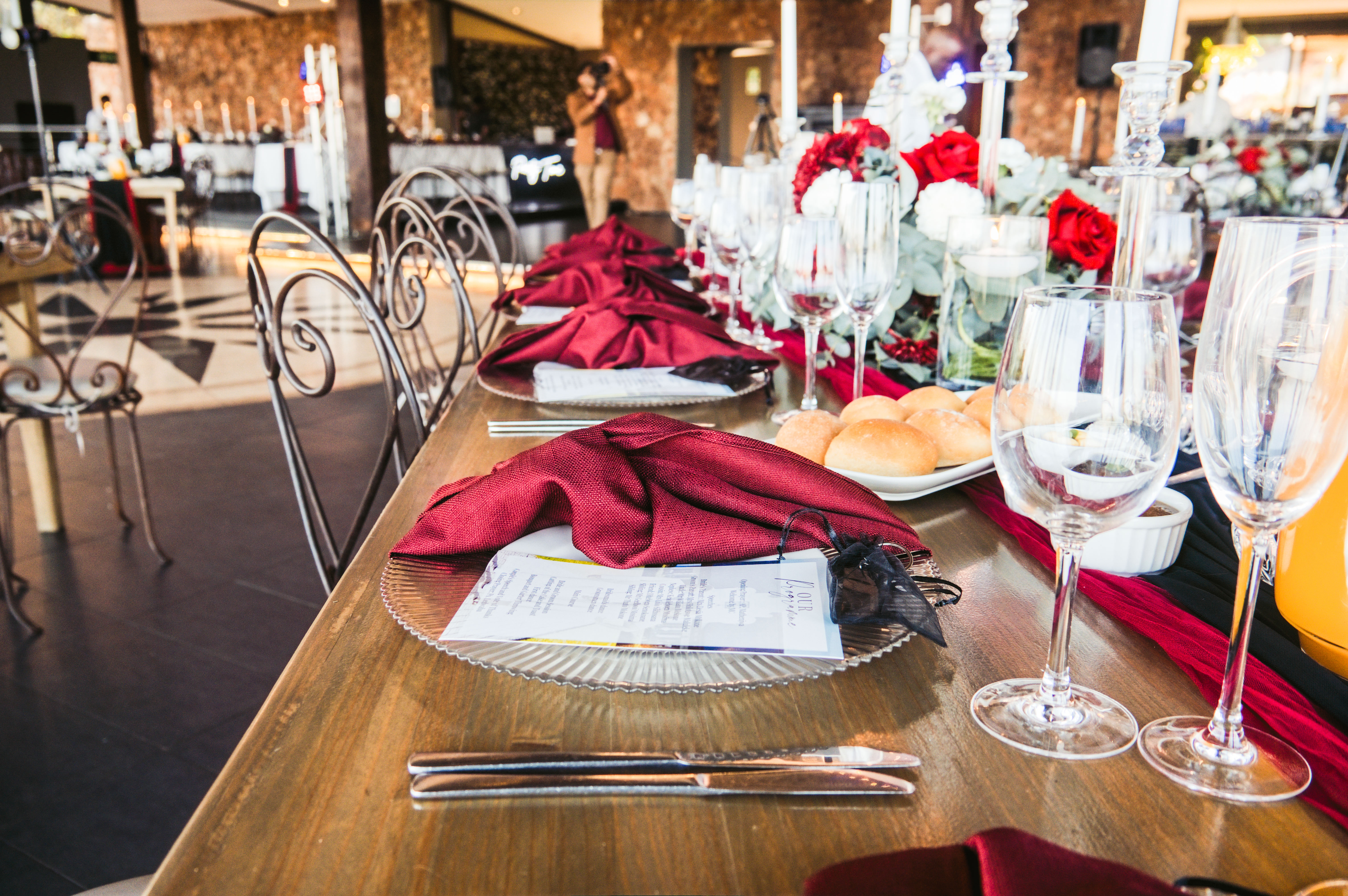 Burgundy napkin place setting with menu card and glassware