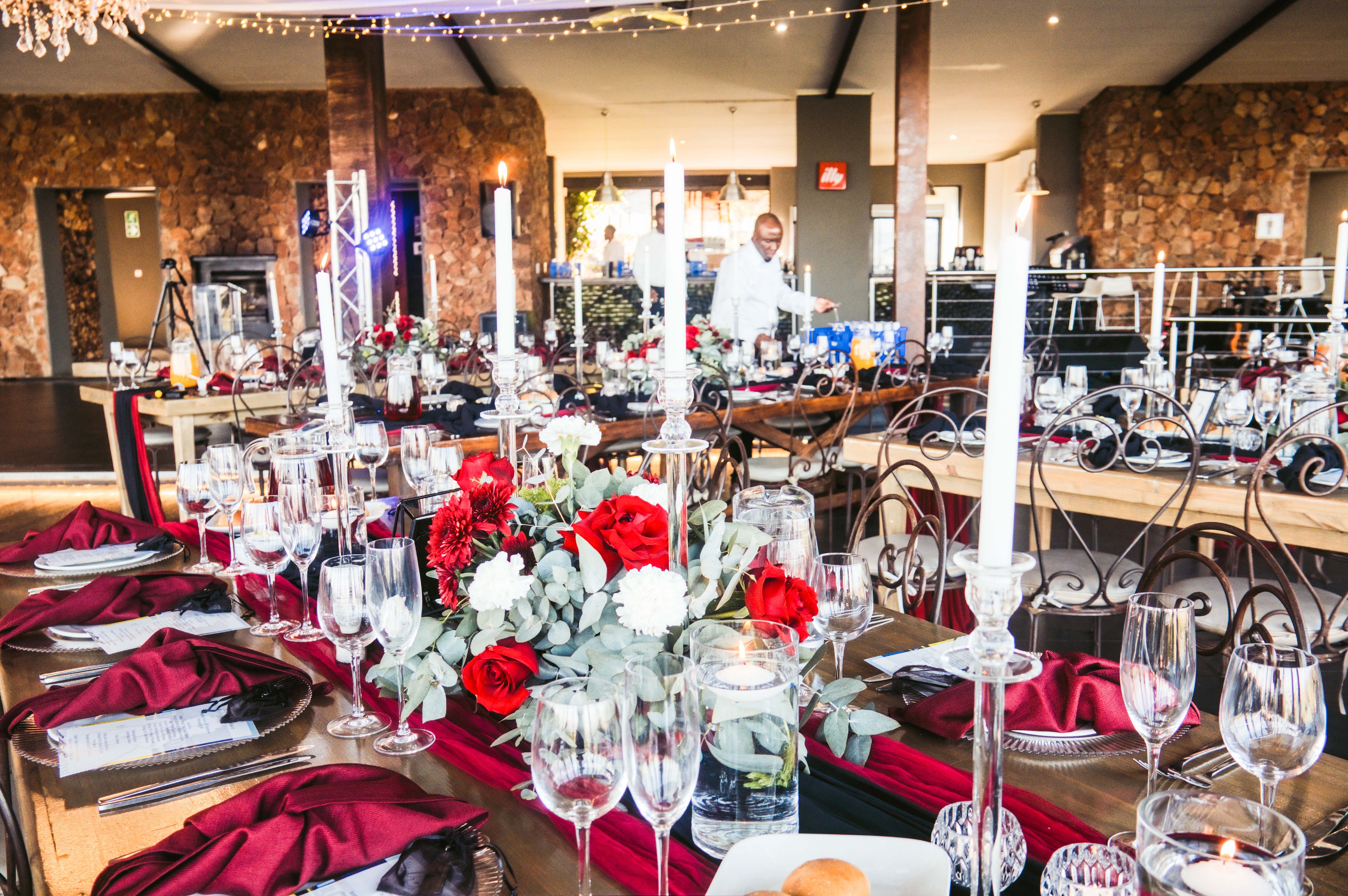 Candlelit reception venue styled with red roses and taper candles