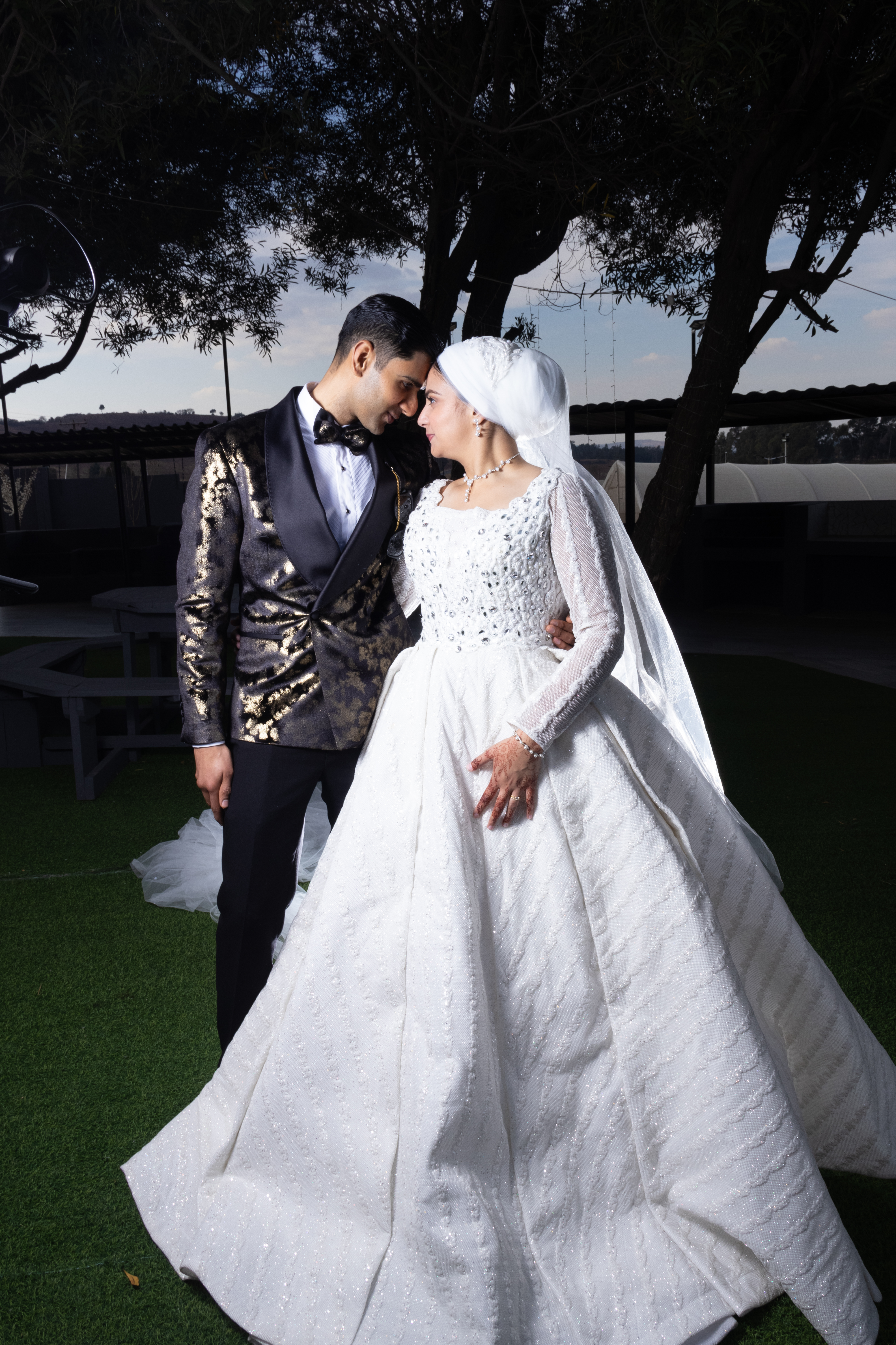 Couple touching foreheads, the bride in a sparkling ballgown