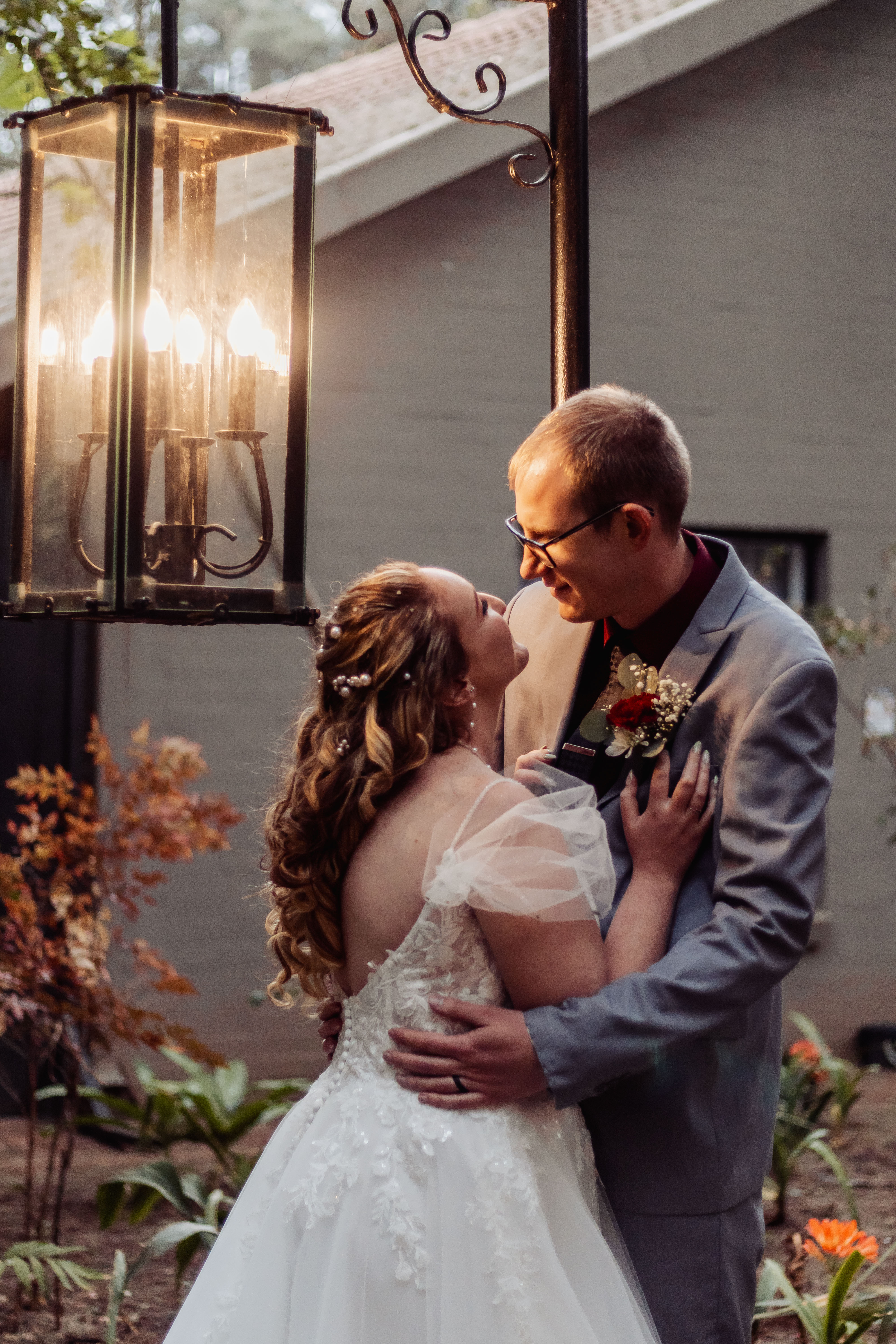 Couple embracing beneath a glowing garden lantern