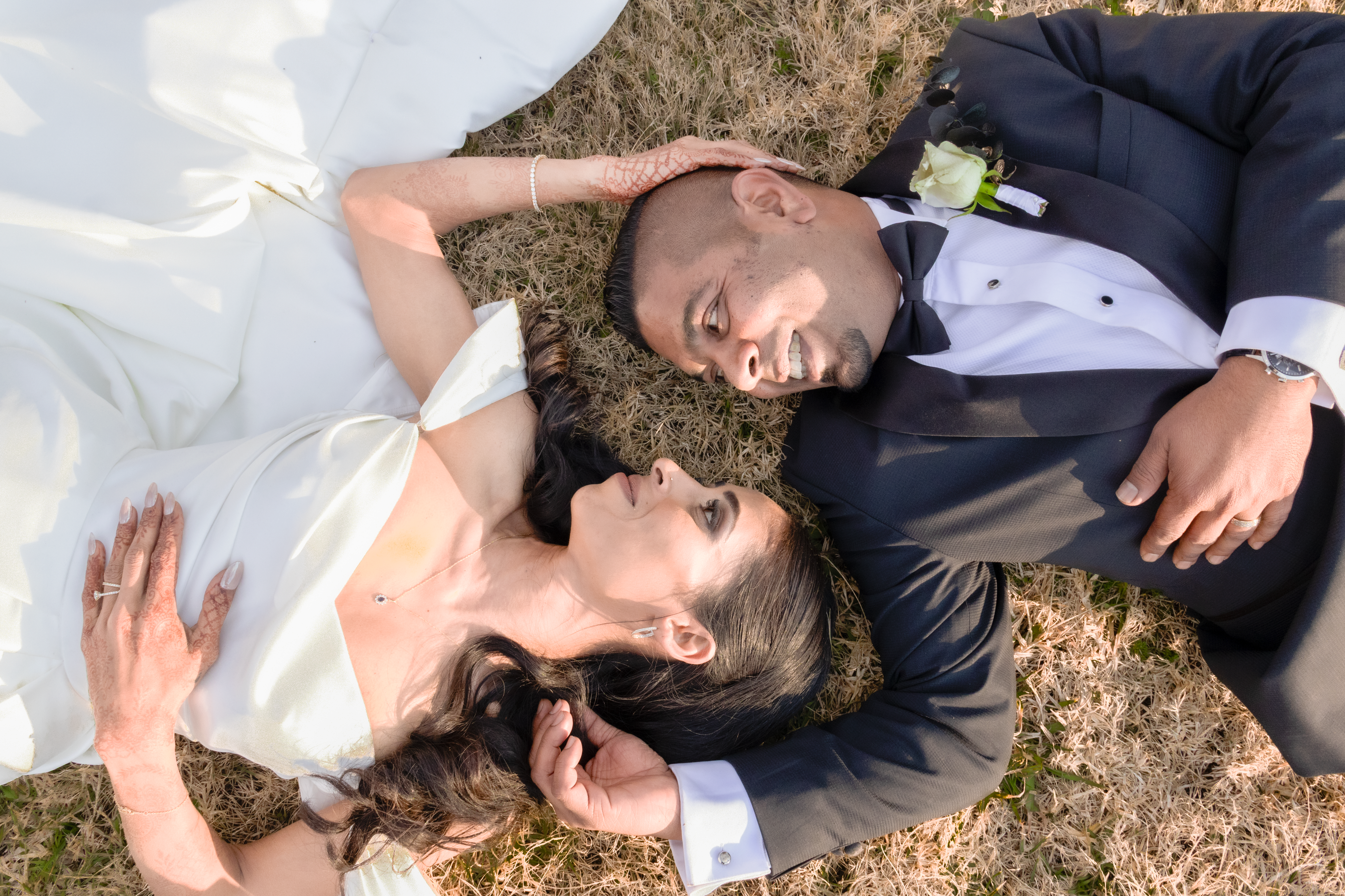 Overhead view of the couple lying on the grass gazing at each other
