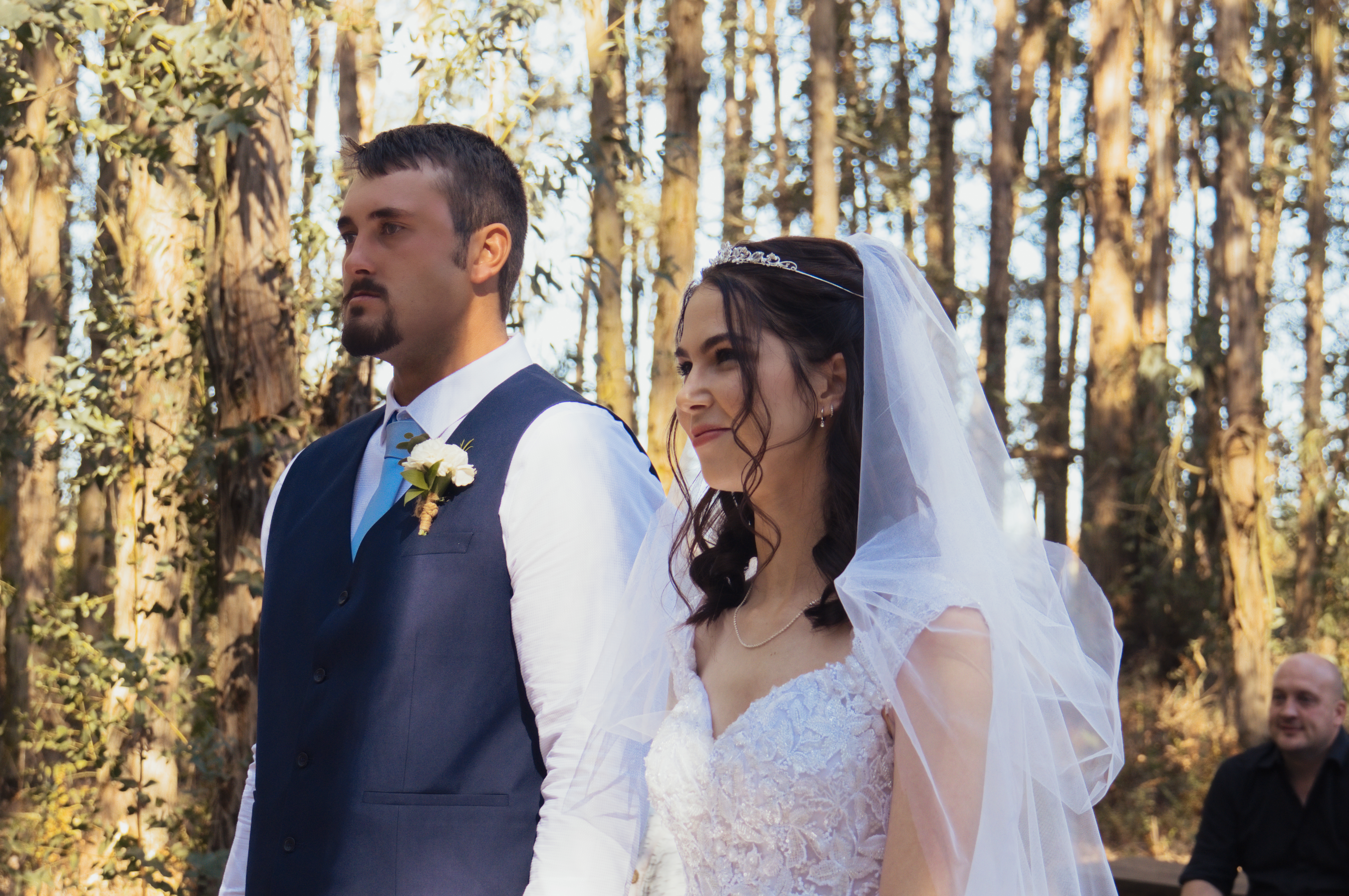 Bride and groom standing together at a forest ceremony
