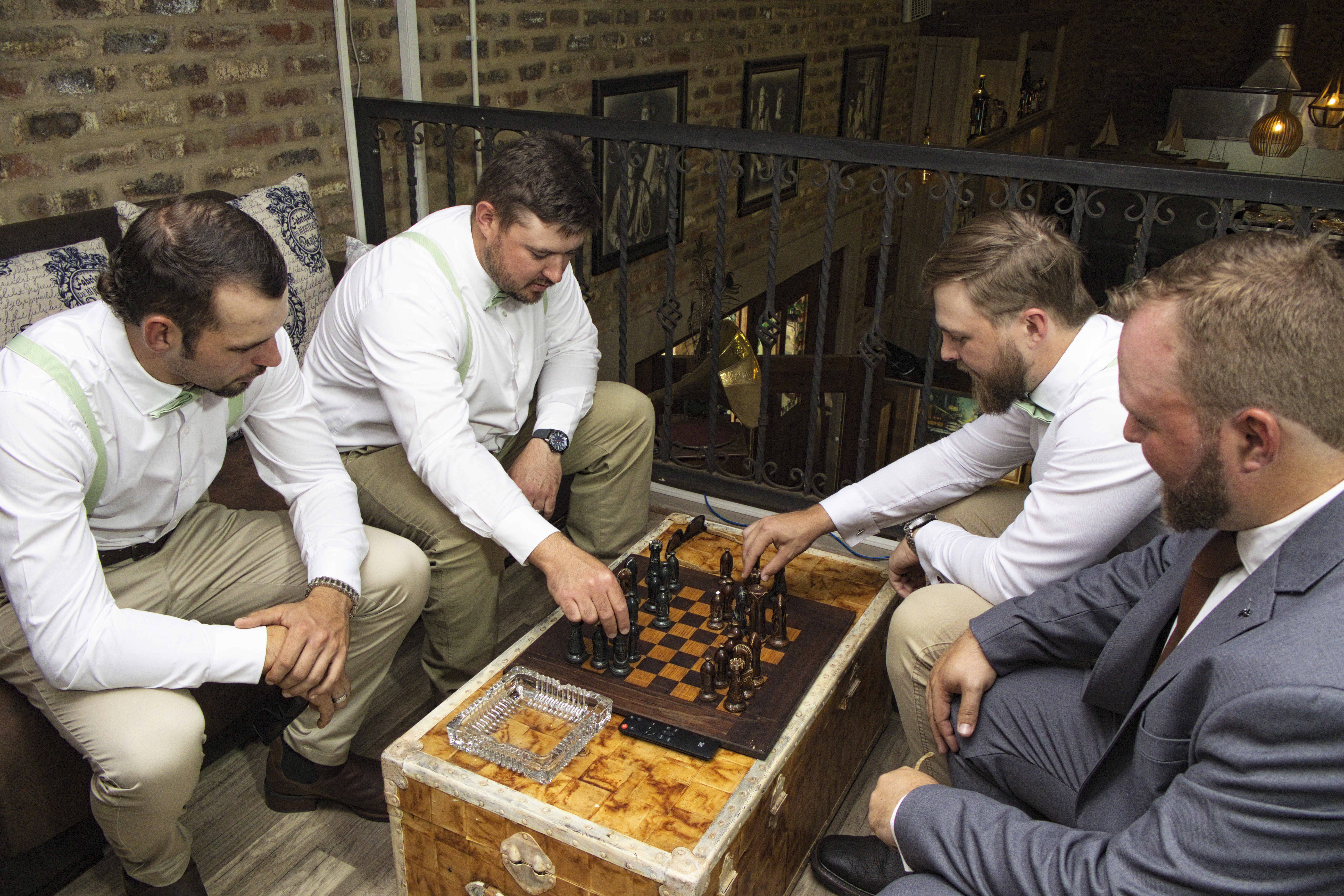 Groom watching his groomsmen play chess before the ceremony