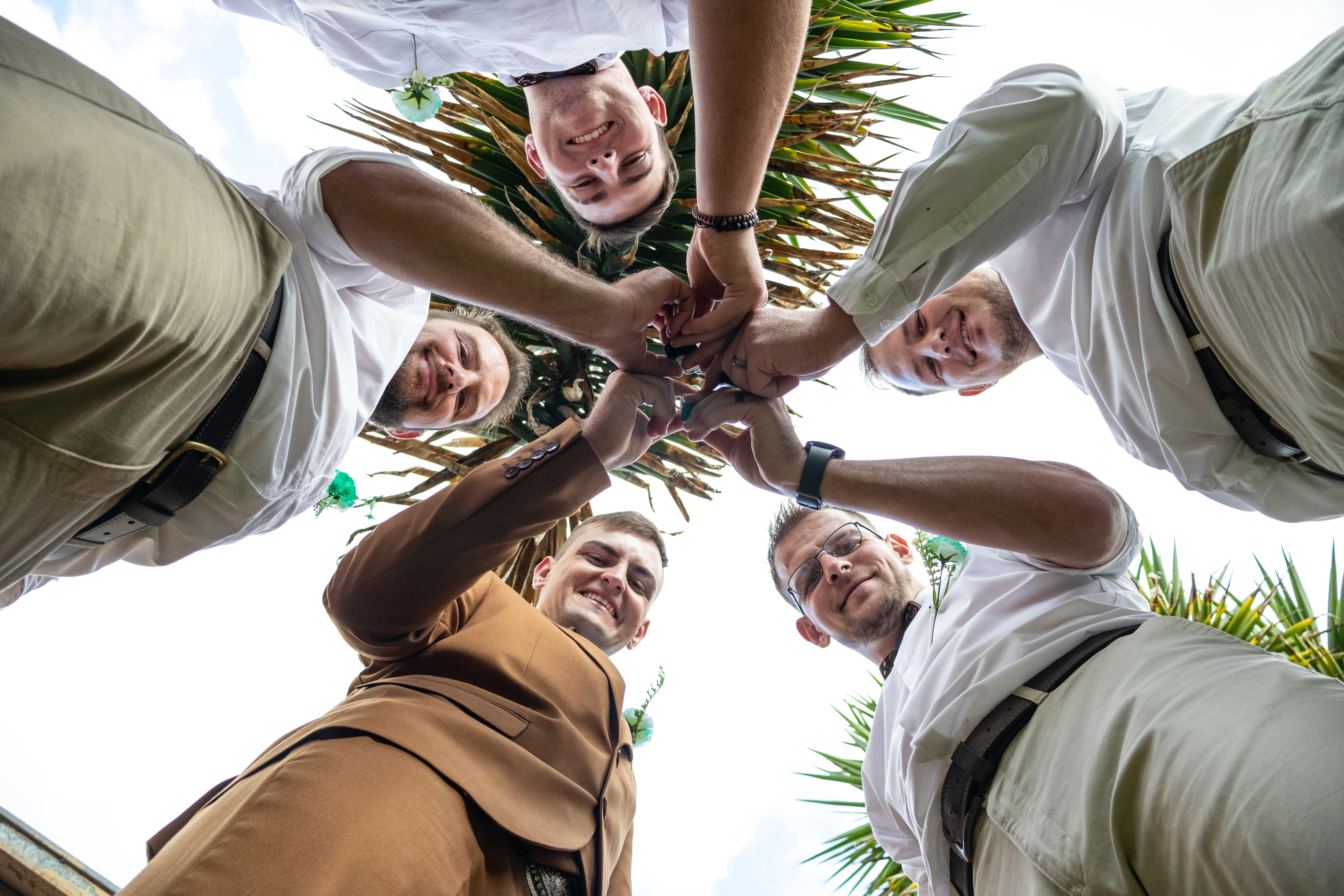 Groom and groomsmen in a circle, photographed from below