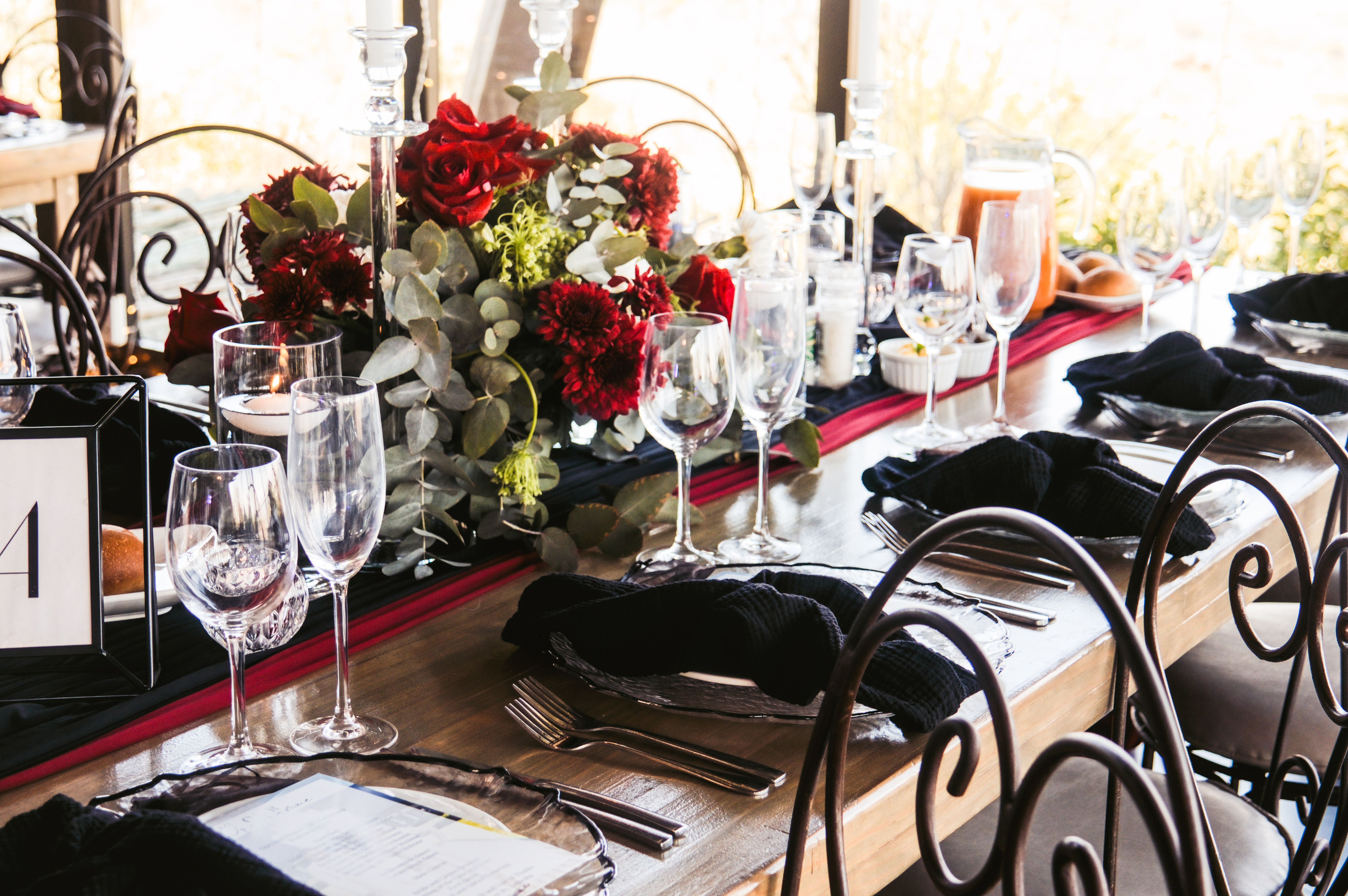 Reception table with a red rose and eucalyptus centrepiece
