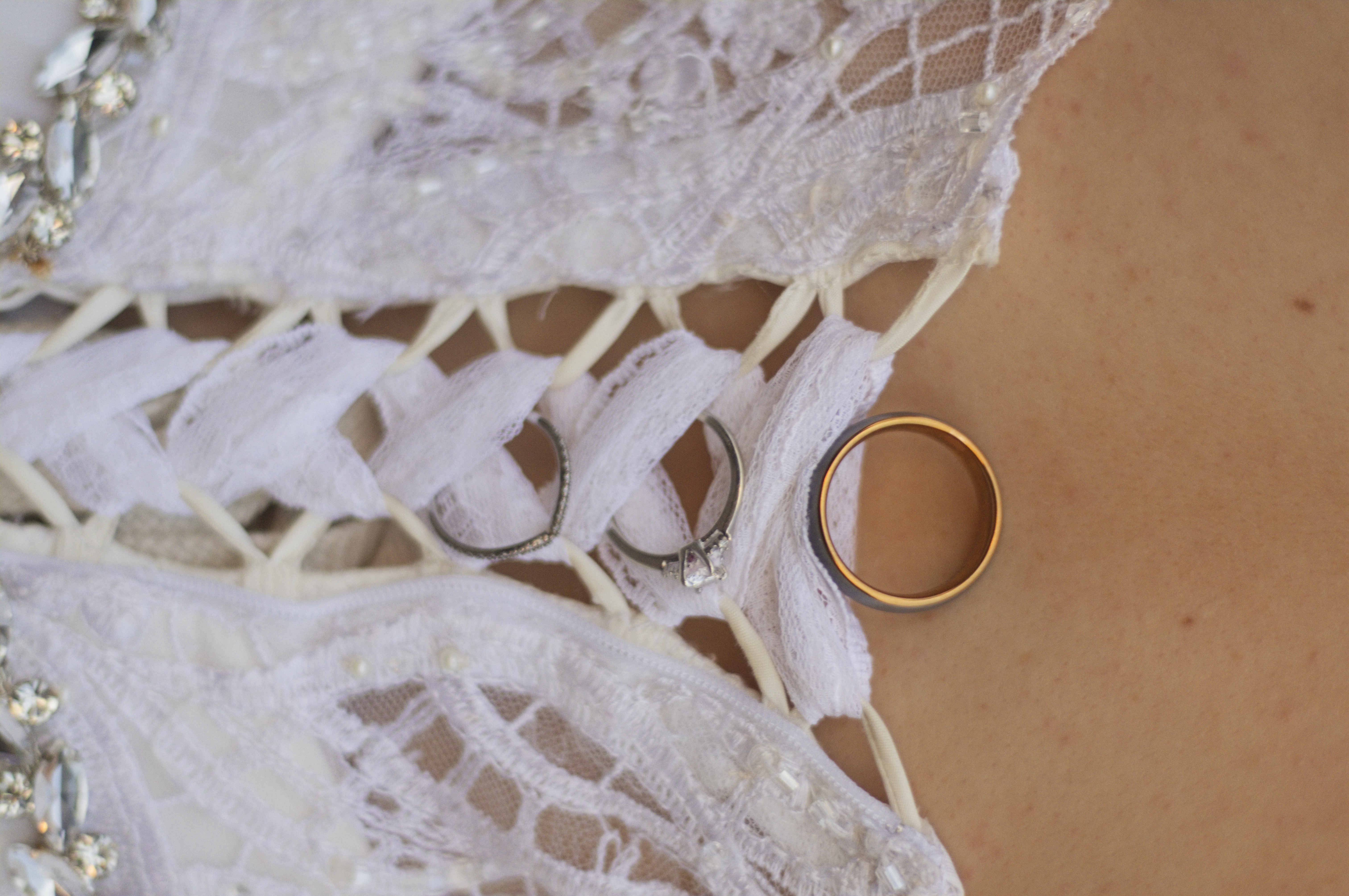 Wedding rings threaded on the bride's lace corset lacing