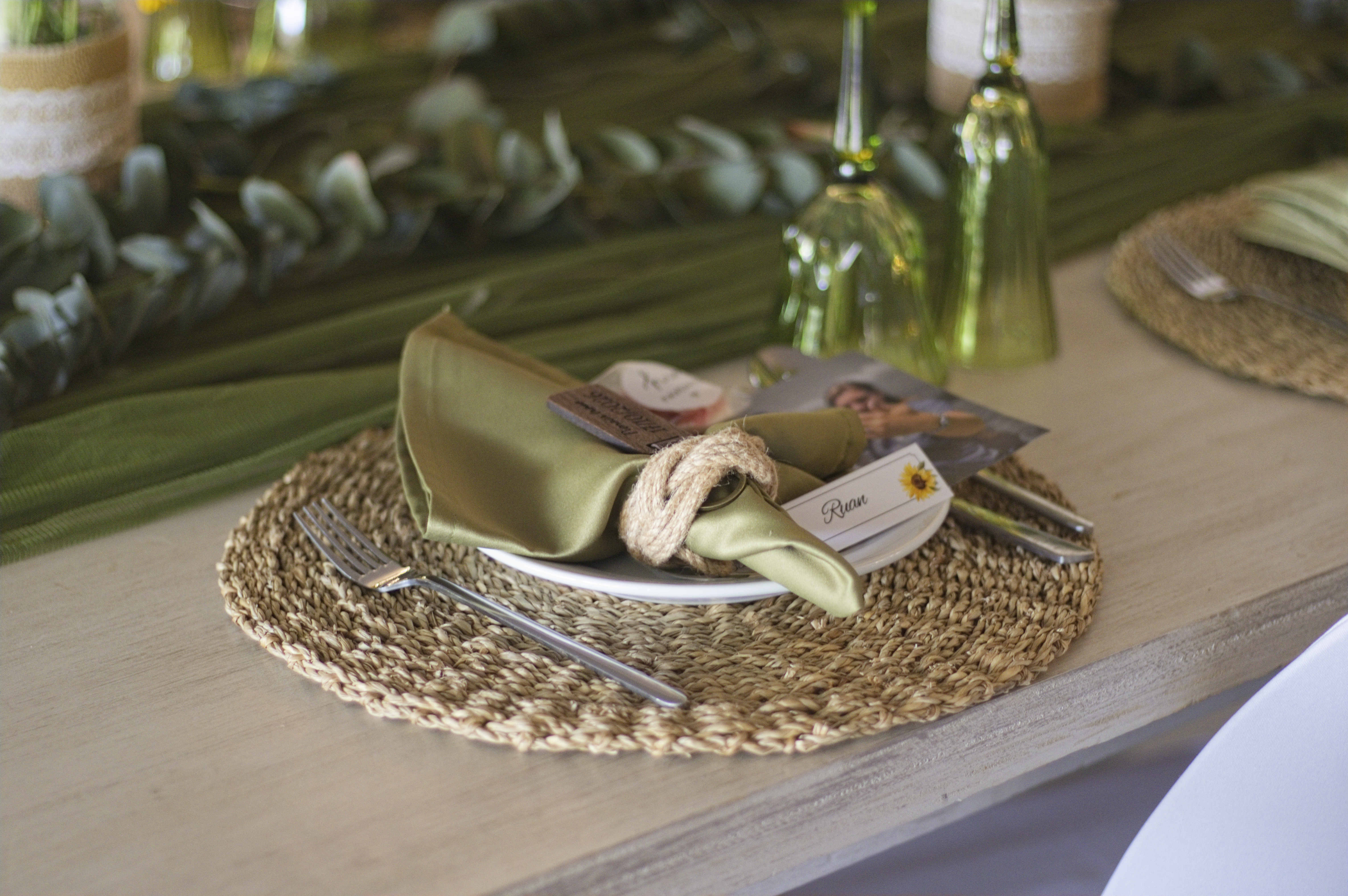 Sage green napkin and rope ring place setting with a name card