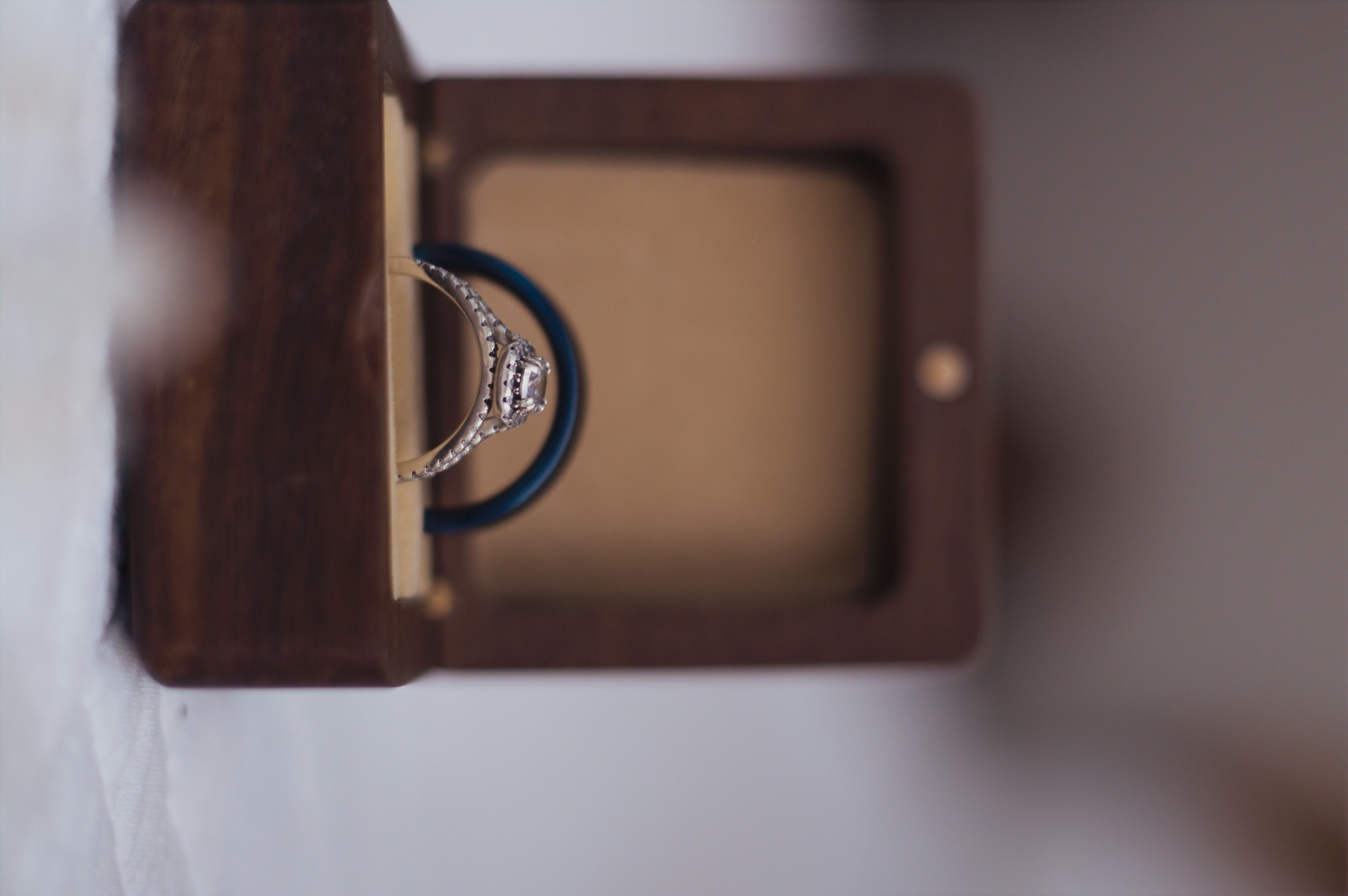 Close-up of engagement ring and wedding band in a wooden box