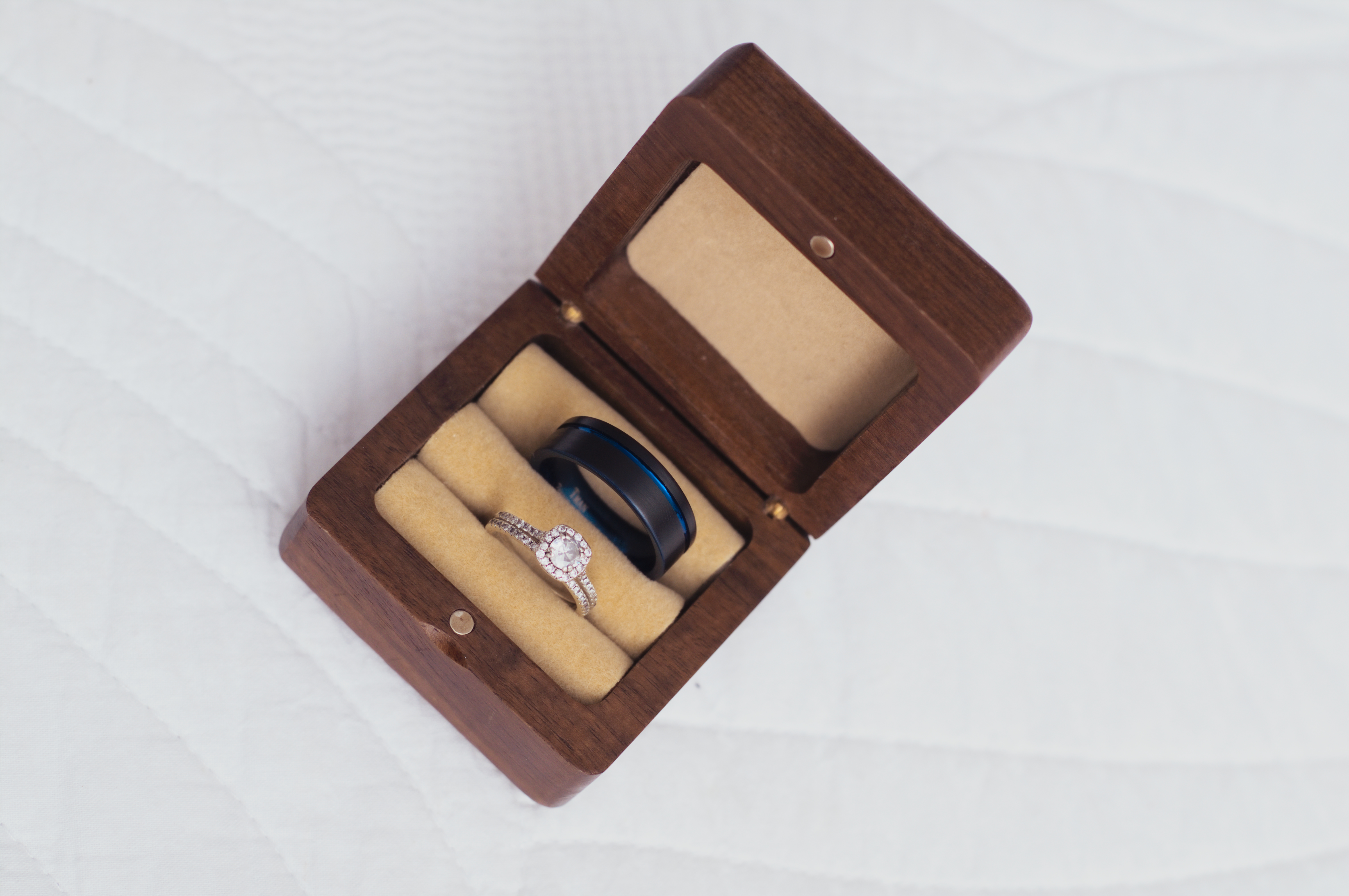 Overhead view of wedding rings in an open wooden ring box